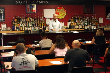 Learn behind an actual bar at the Riverside, California Bartending School.